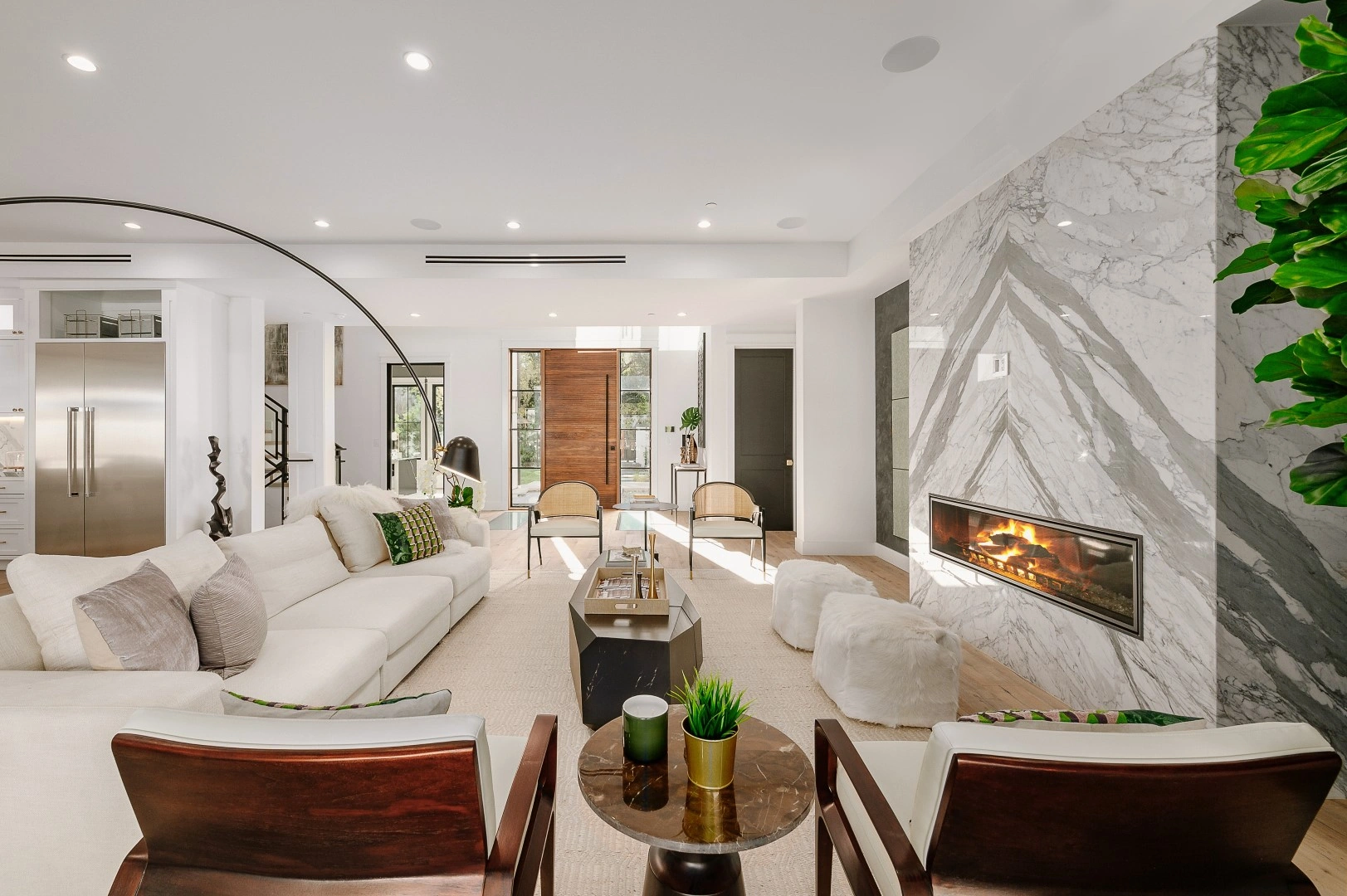 Open-concept living room in a Los Angeles addition with a floor-to-ceiling marble fireplace wall