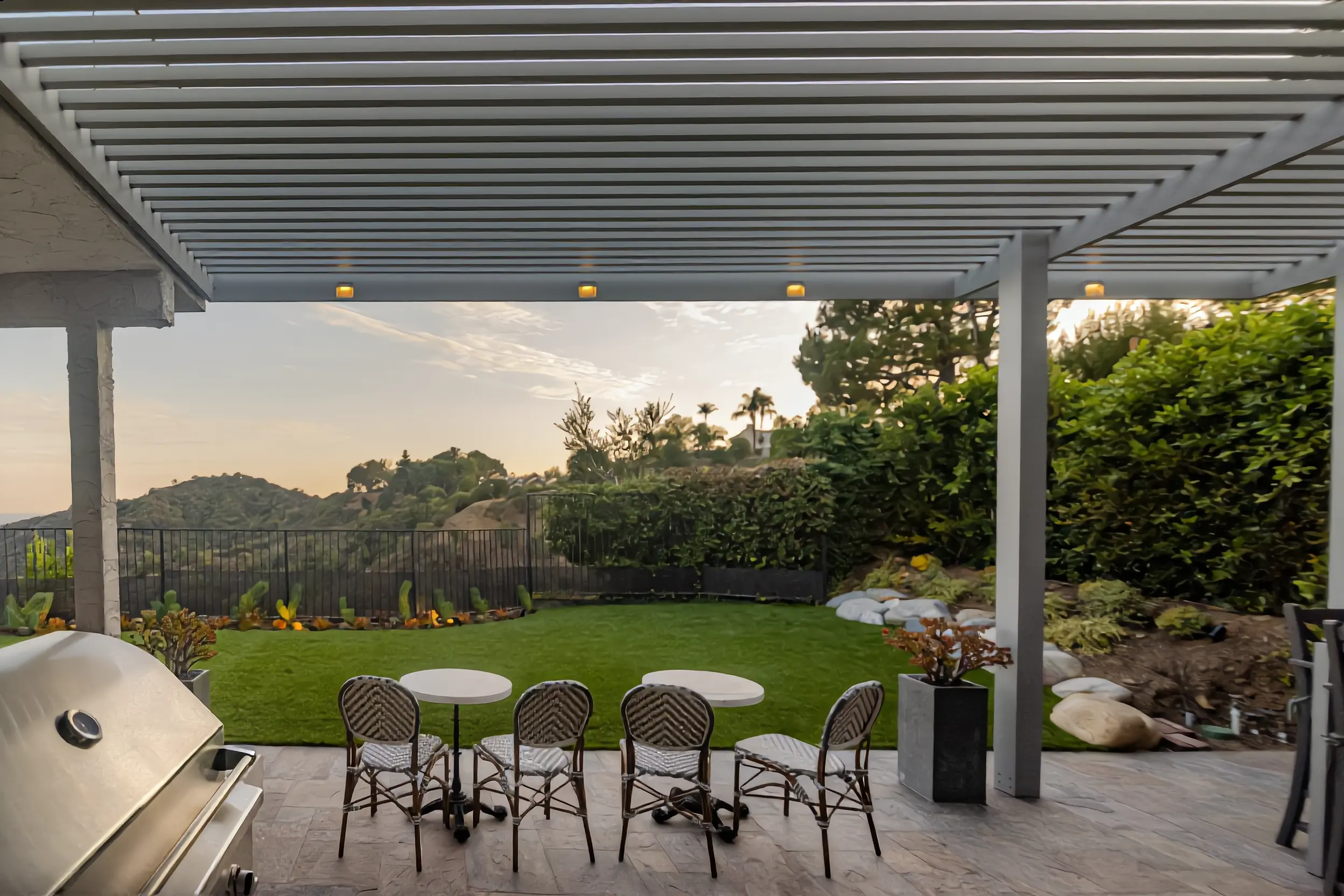 Louvered aluminum patio cover attached to a Los Angeles home with a hillside view