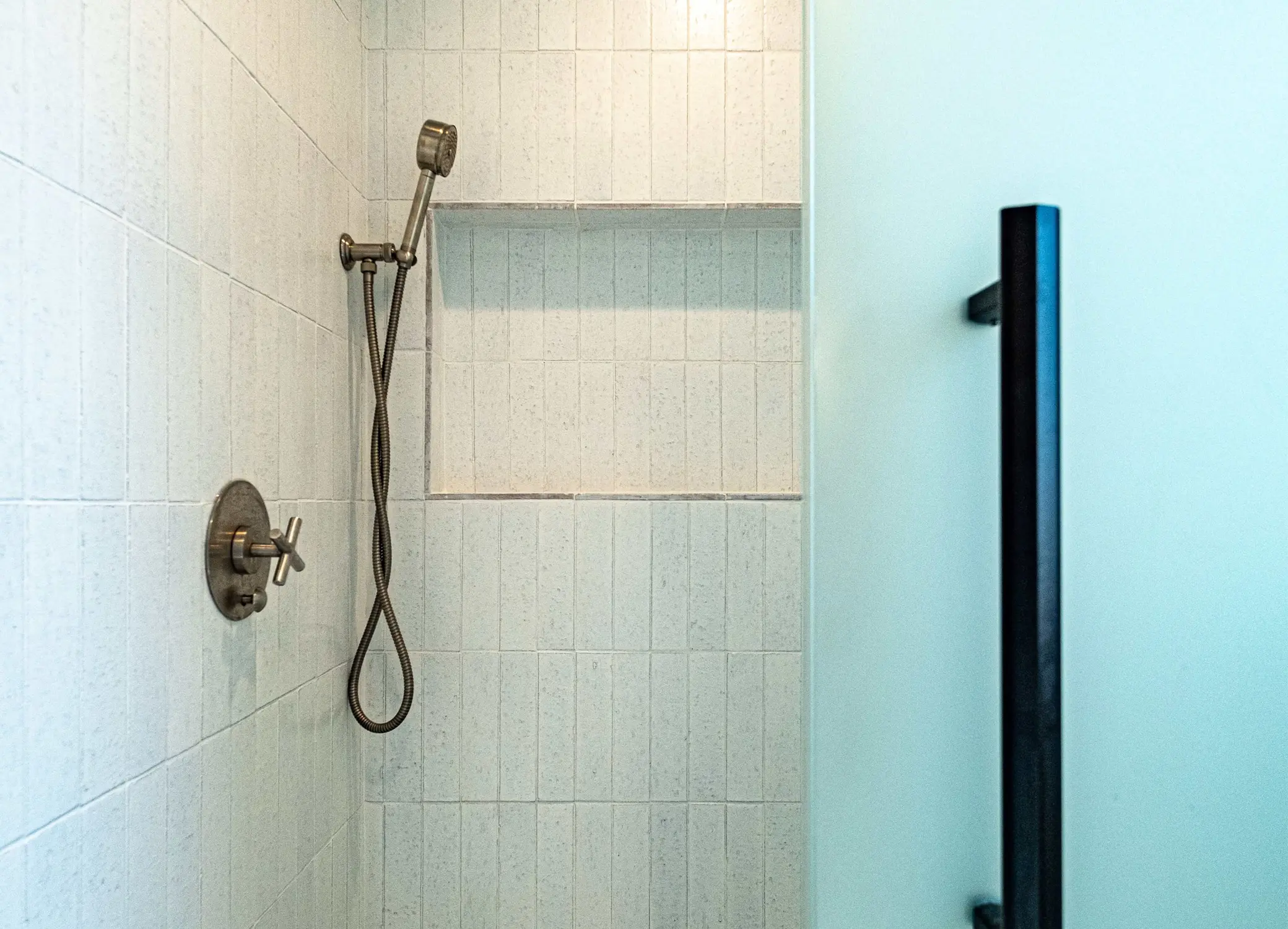 Bathroom remodel in Los Angeles with a white subway tile shower and handheld sprayer