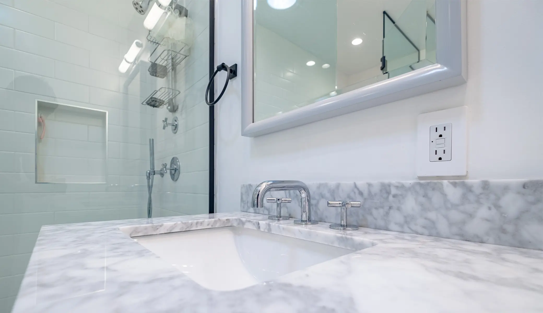 Bathroom remodel in Los Angeles with a marble vanity and glass shower corner