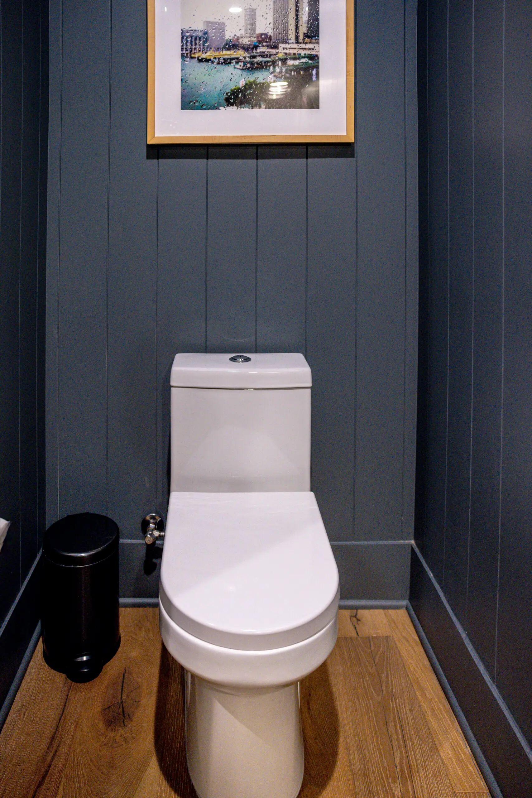 Bathroom remodel in Los Angeles with navy wood paneling and framed art