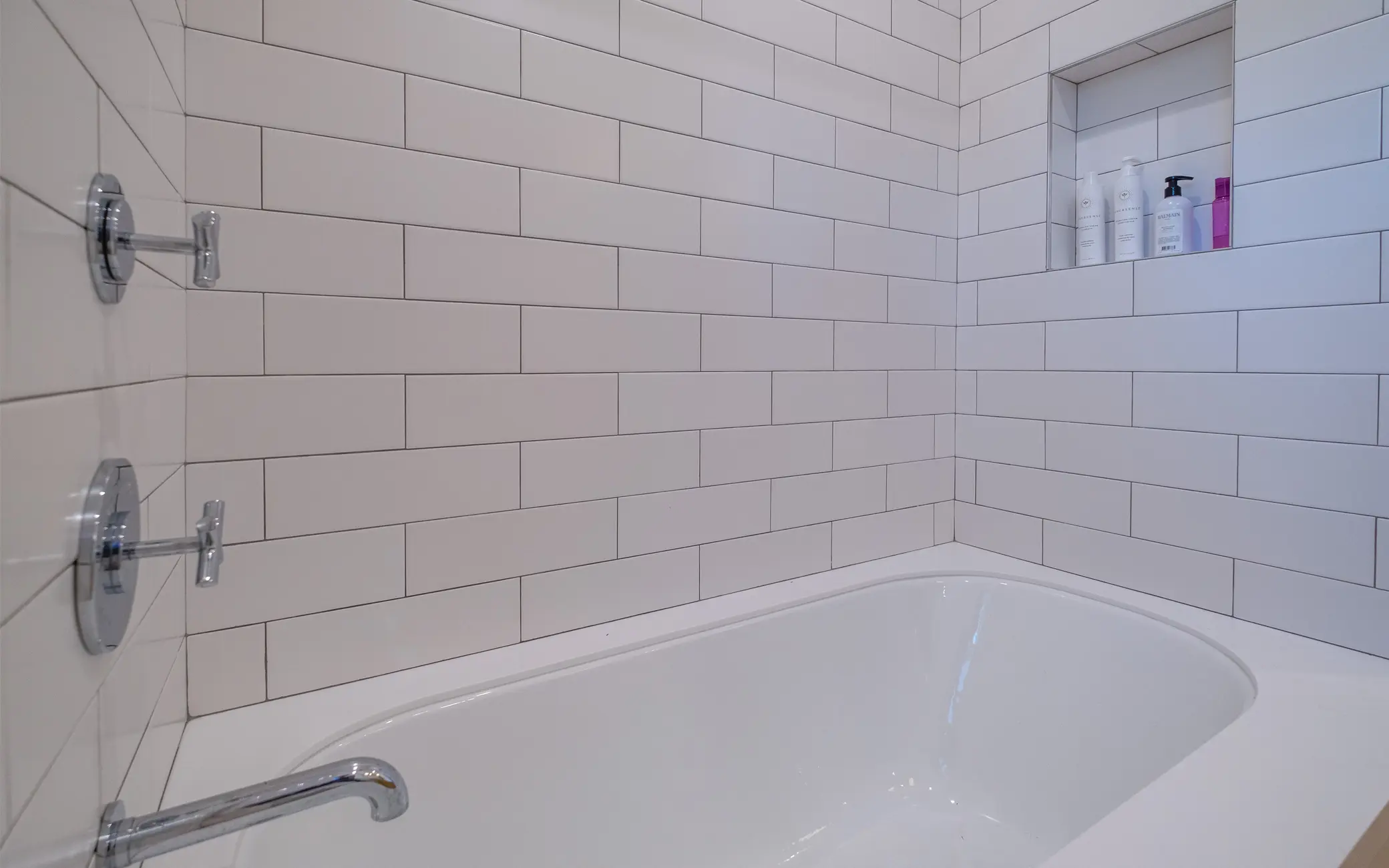 Bathroom remodel in Los Angeles with a white subway tile shower and built-in niche