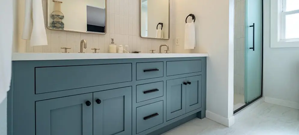 Bathroom remodel in Los Angeles with a teal double vanity and round mirrors