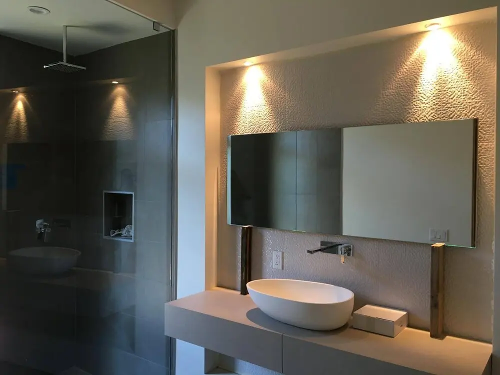 Bathroom remodel in Los Angeles with an oval vessel sink and wood accent lighting
