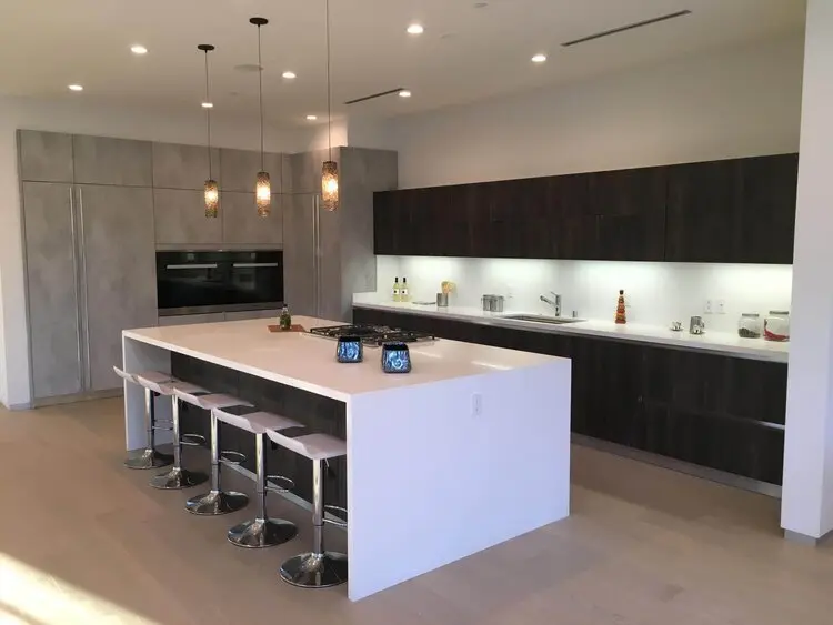 Contemporary kitchen remodel in Los Angeles with dark cabinetry and a waterfall island