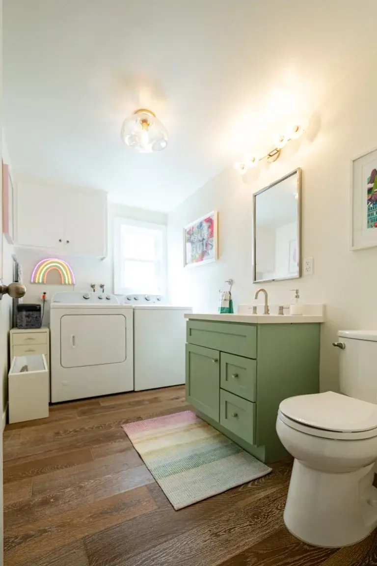 Combined laundry and bathroom space with a green vanity in a Los Angeles full home renovation