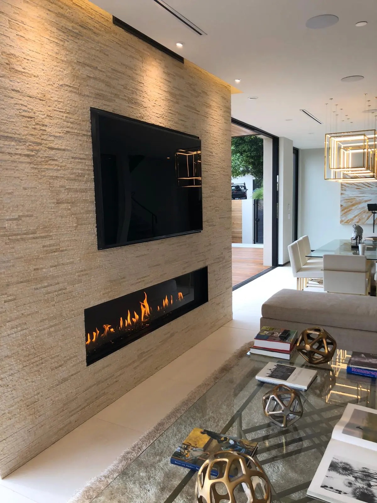 Stacked stone fireplace wall with a mounted TV in a Los Angeles full home renovation