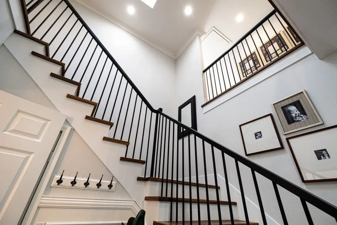 Staircase with a family photo gallery wall in a Los Angeles full home renovation