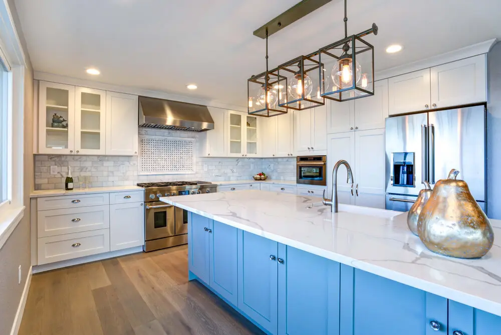 Kitchen remodel in Los Angeles with a blue island and marble subway tile backsplash