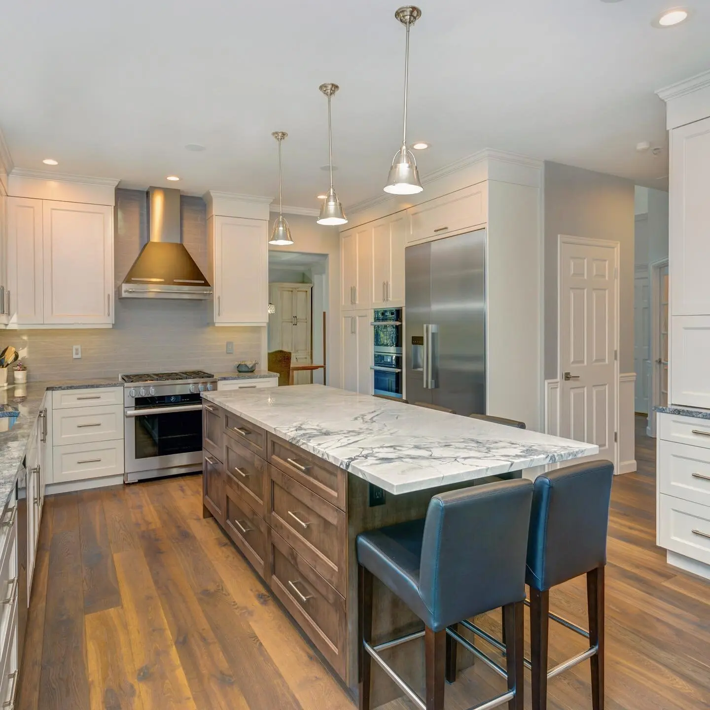 Kitchen remodel in Los Angeles with a marble island and wide-plank wood flooring