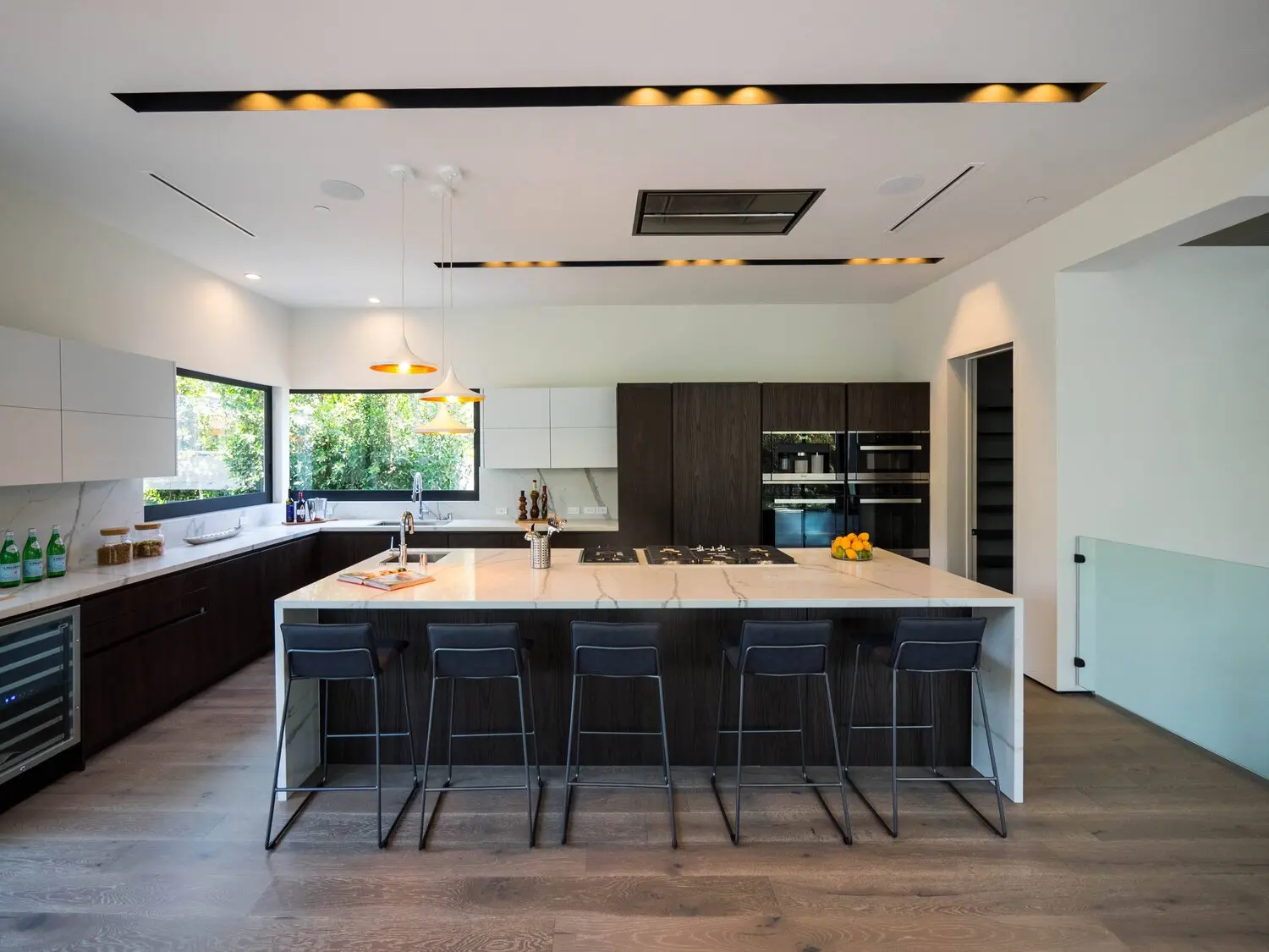 Luxury kitchen remodel in Los Angeles with a large marble island and recessed lighting