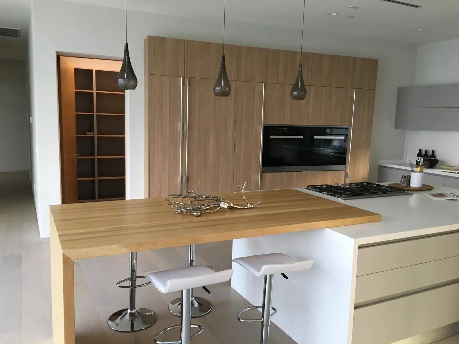 Modern kitchen remodel in Los Angeles with custom wood cabinetry and a wood bar counter
