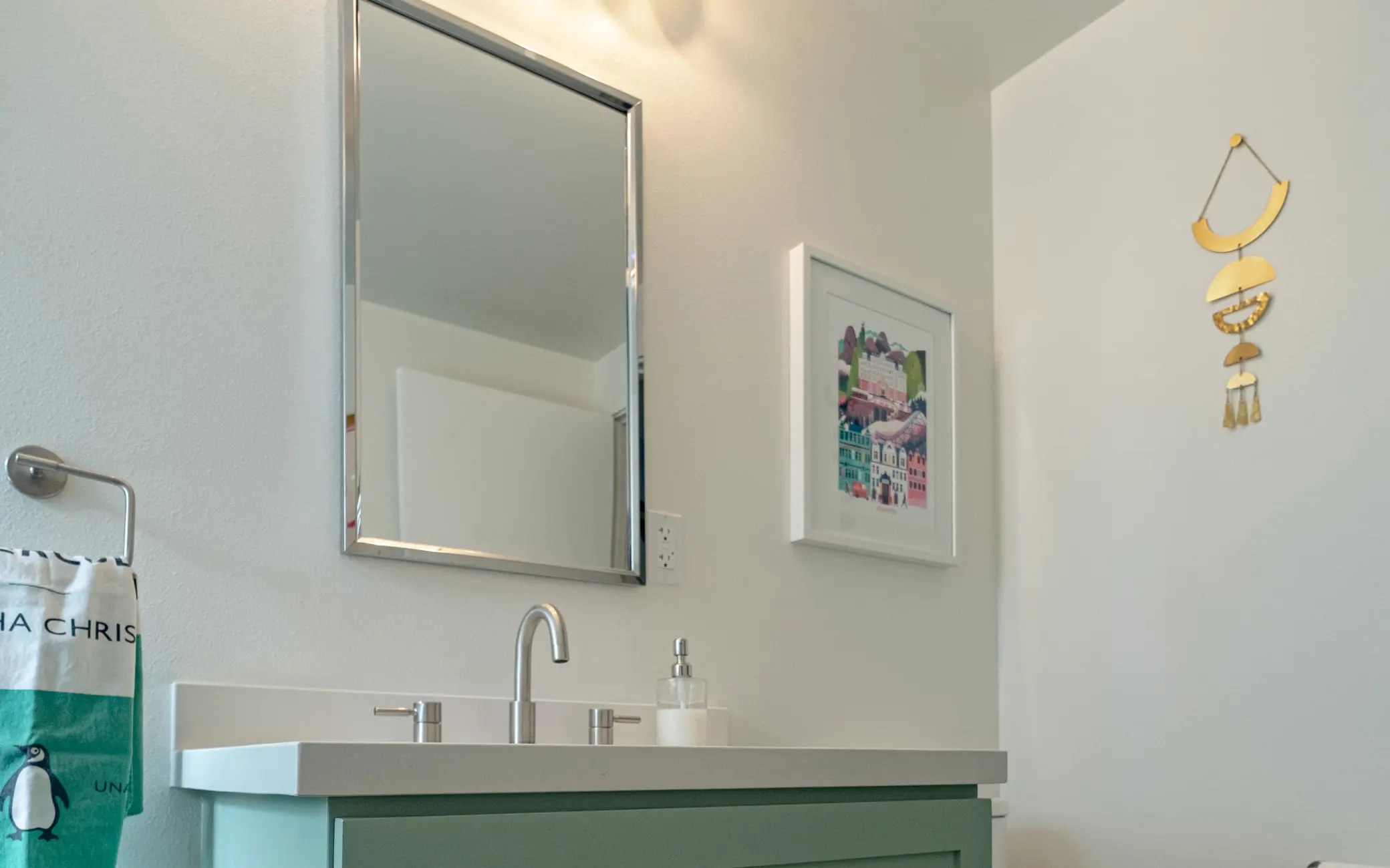 Powder room remodel in Los Angeles with a green vanity and gold accents