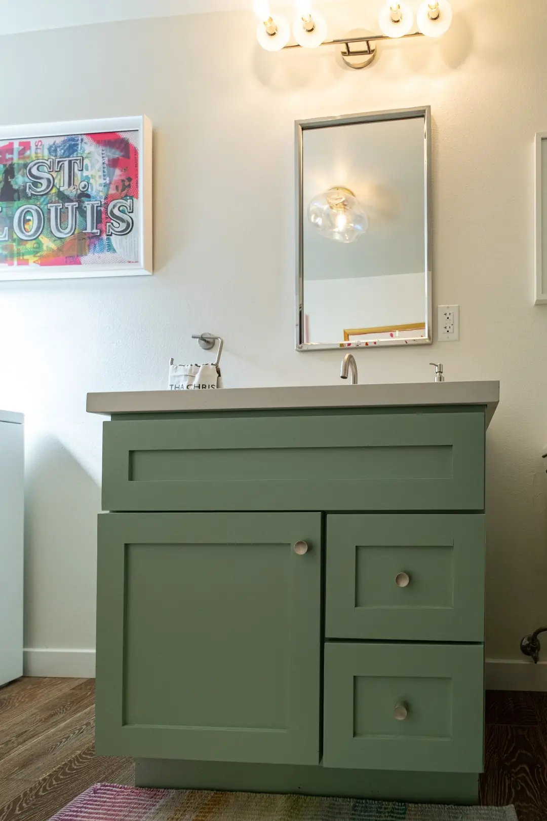 Sage green shaker vanity with a white quartz top and brushed nickel faucet in a Burbank remodel