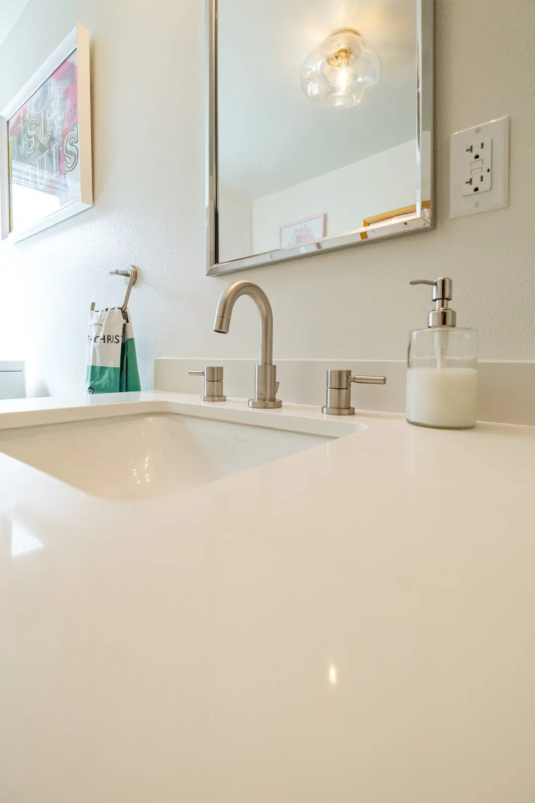 Undermount sink with a brushed nickel faucet on a white quartz counter in a Burbank bathroom remodel