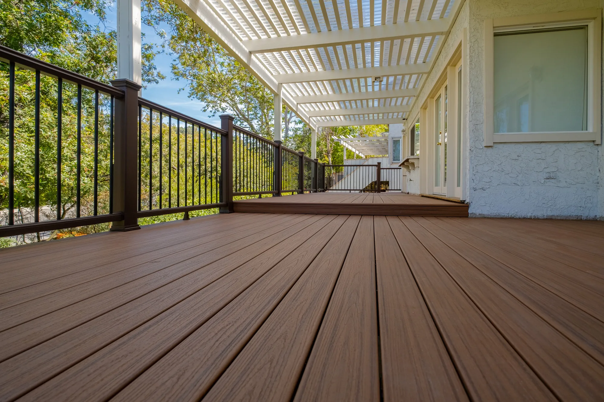 Warm composite decking boards under a white patio cover on a custom deck in Beverly Glen, Los Angeles