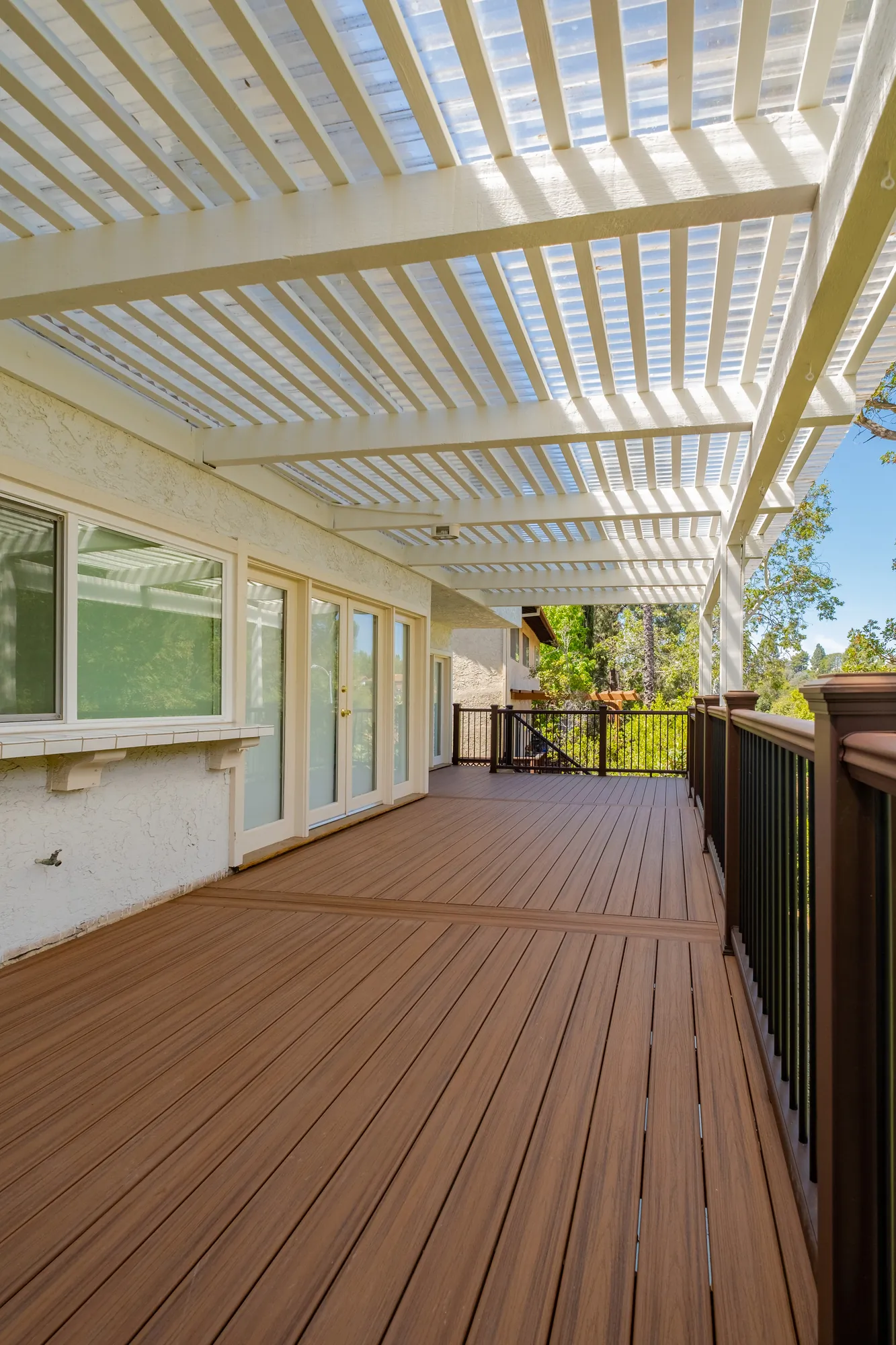 Covered outdoor living area with French doors opening onto a custom deck in Beverly Glen, Los Angeles