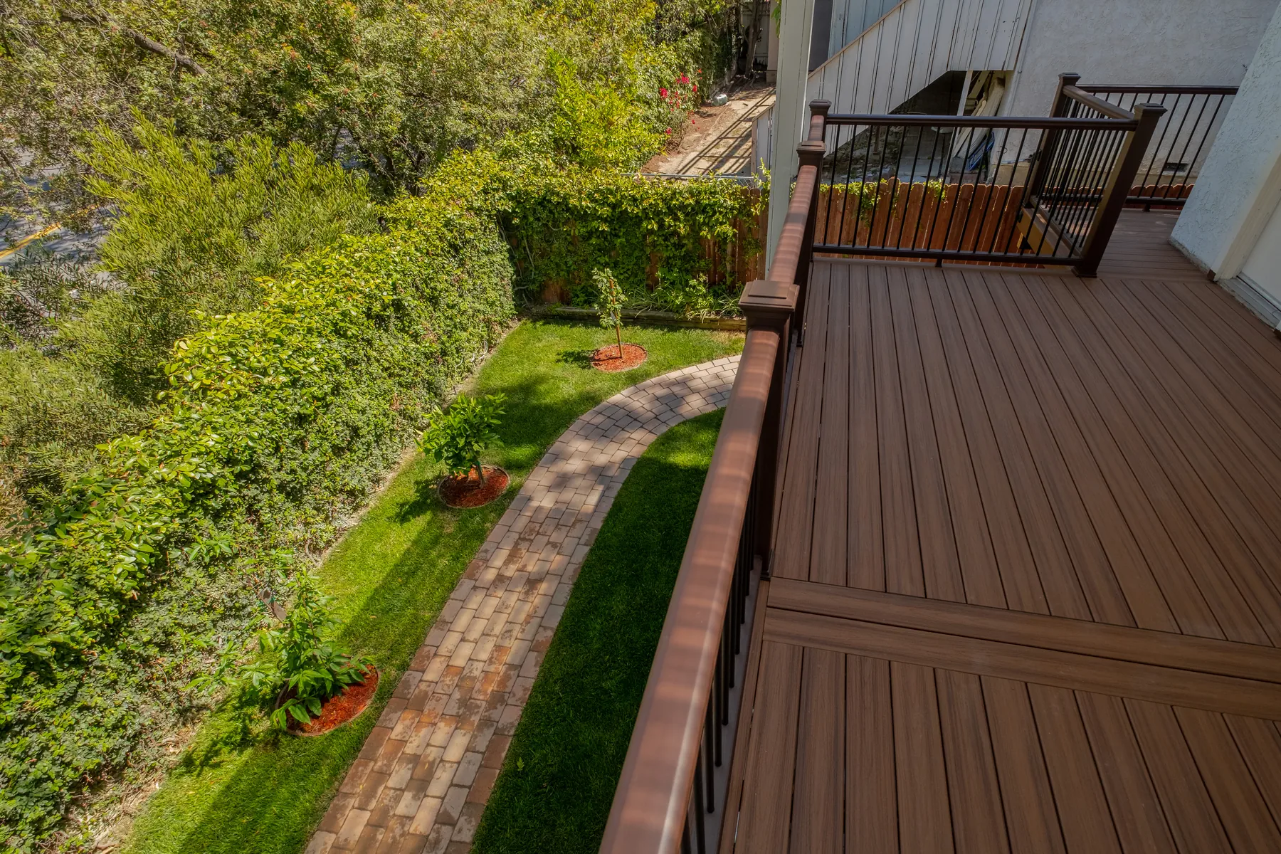 View from a custom deck overlooking landscaped yard and curved path in Beverly Glen, Los Angeles
