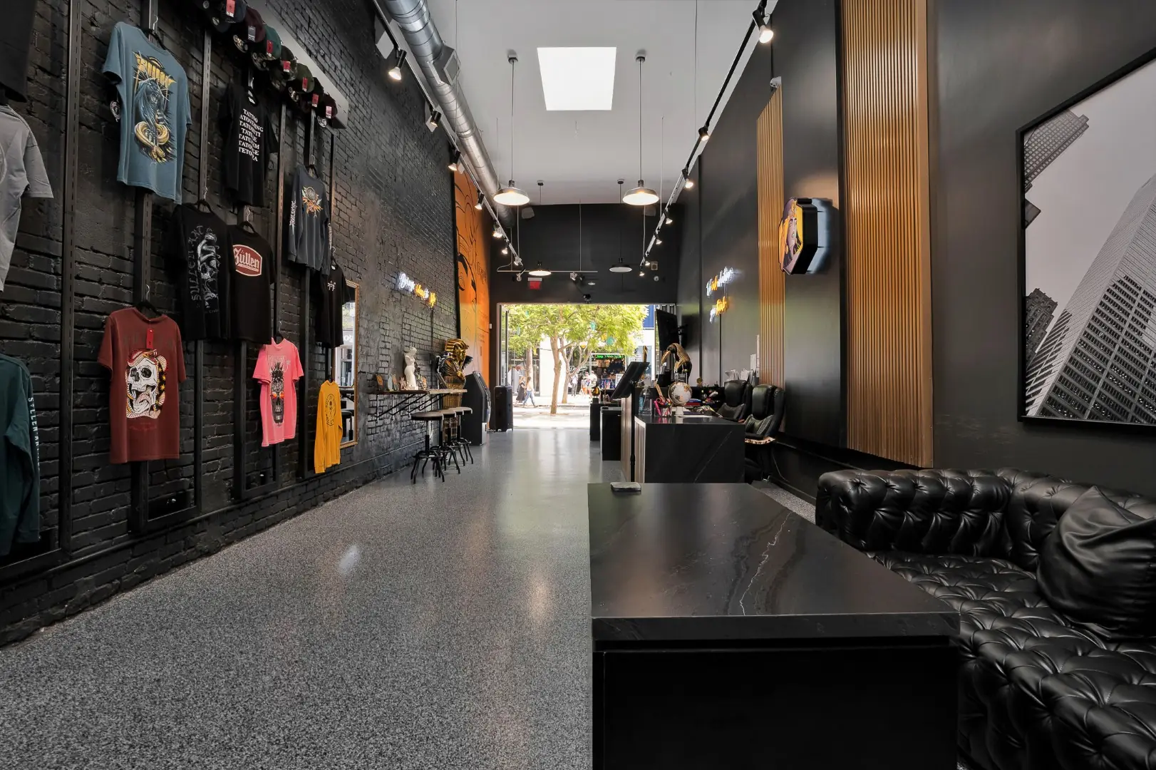 Cleopatra Tattoo merchandise wall on painted brick with a long view through the studio in Santa Monica