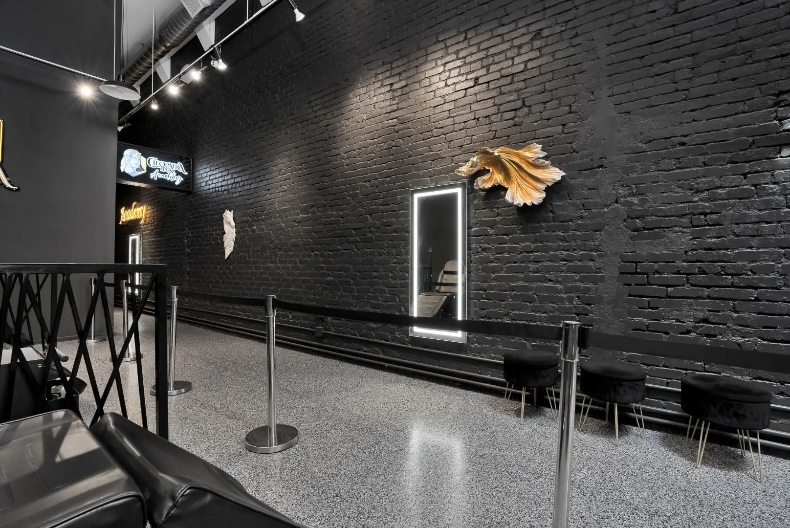 Cleopatra Tattoo station area with backlit mirrors, stanchions, and track lighting in Santa Monica