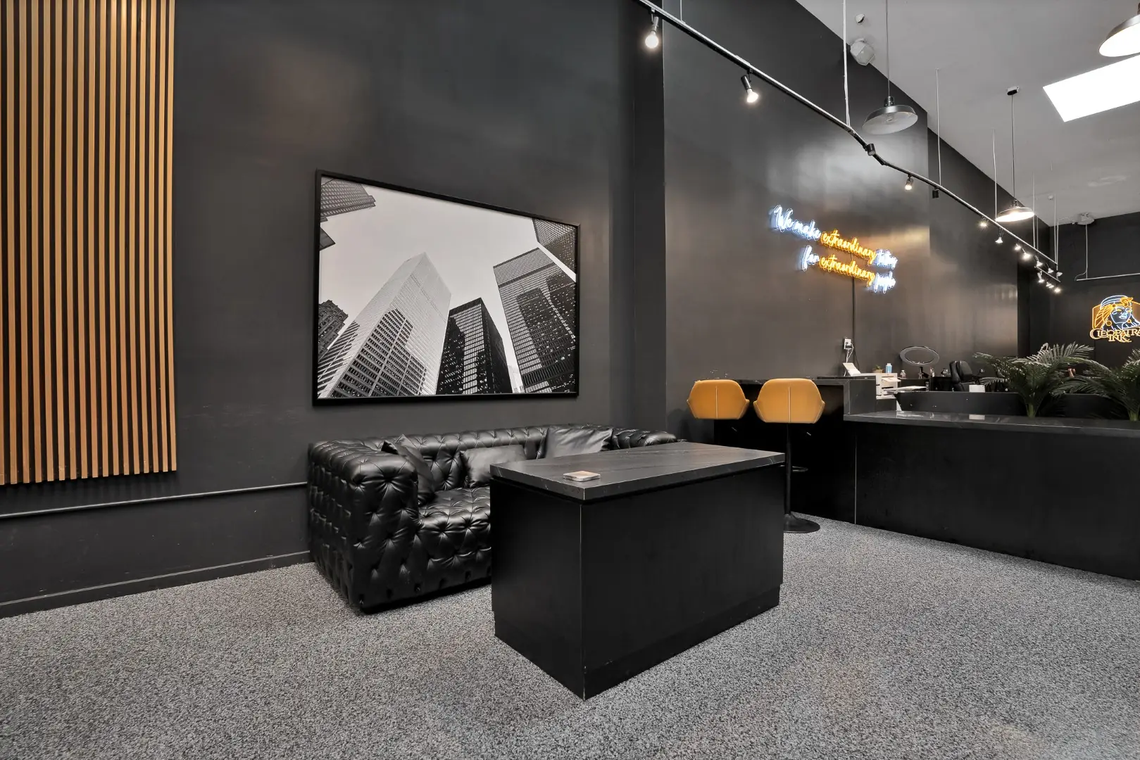 Cleopatra Tattoo waiting area with a leather sofa, framed art, and track lighting in Santa Monica