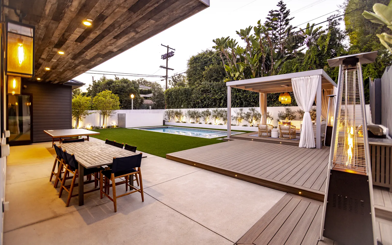 Custom backyard pool with modern pergola and outdoor dining in Cheviot Hills by Adept Builders & Design