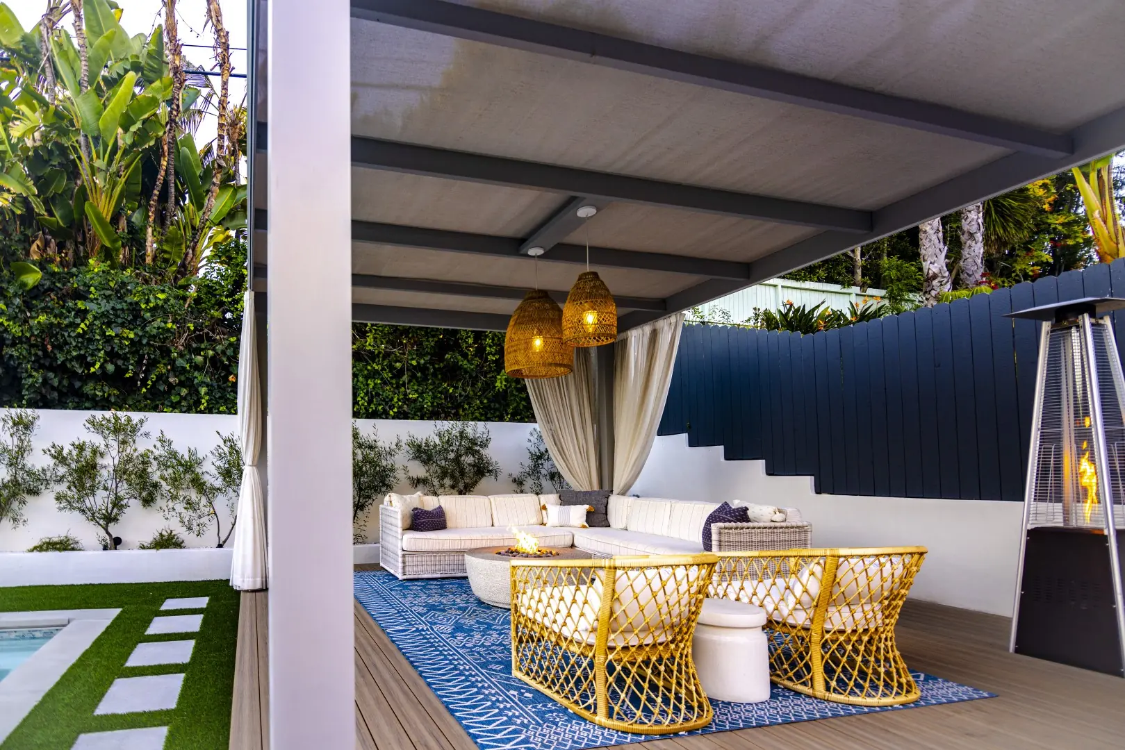 Sheens Project curtained pergola lounge with woven pendant lights and a fire pit table on the composite deck in Los Angeles