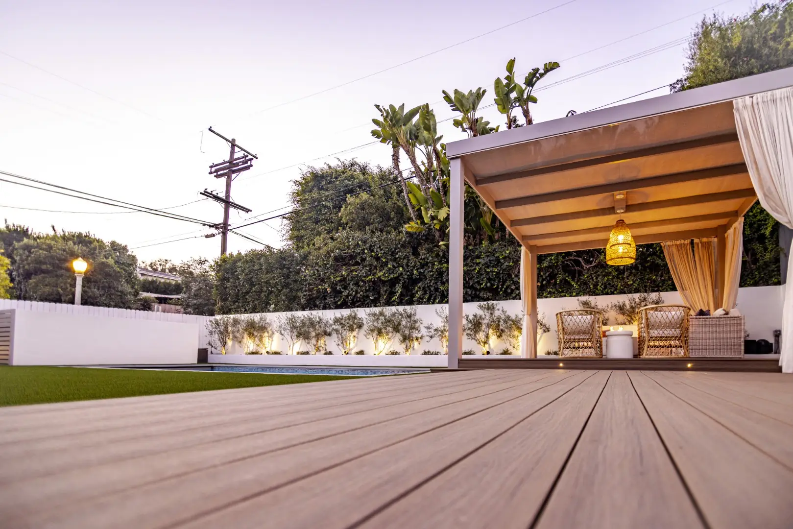 Sheens Project composite deck boards leading to the curtained cabana at dusk in Los Angeles