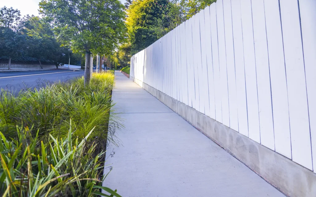 Drought-tolerant side-yard landscape with clean concrete path in Cheviot Hills