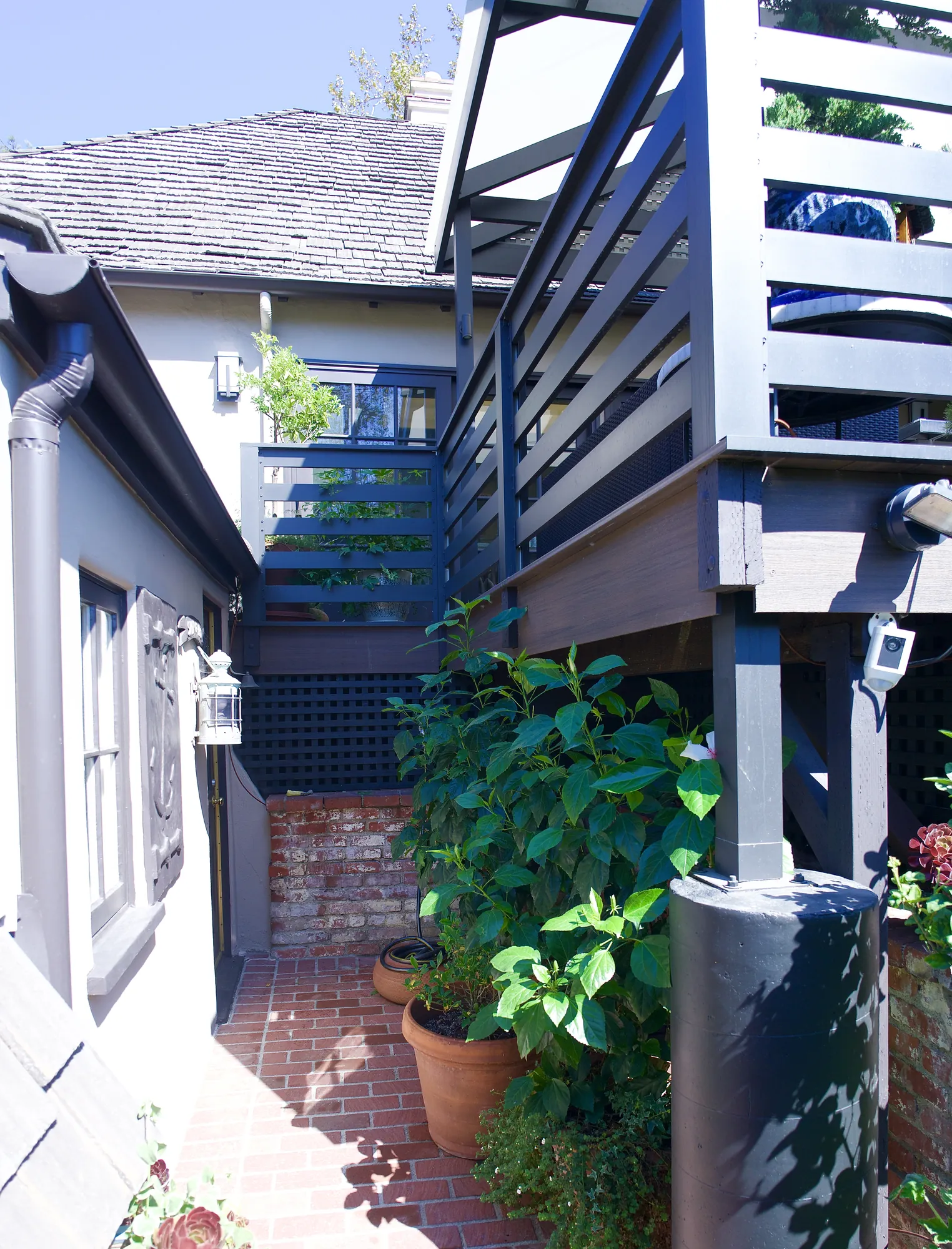 Elevated composite deck above a brick patio and container garden in Los Angeles