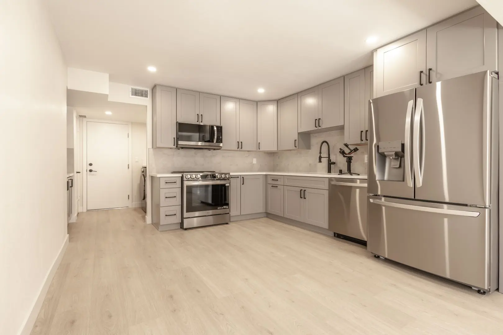 Kitchen with gray shaker cabinets and stainless appliances in a Northridge full-home renovation