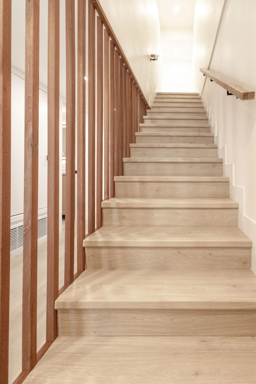 Light wood stair treads framed by vertical wood slats in a Northridge full-home renovation