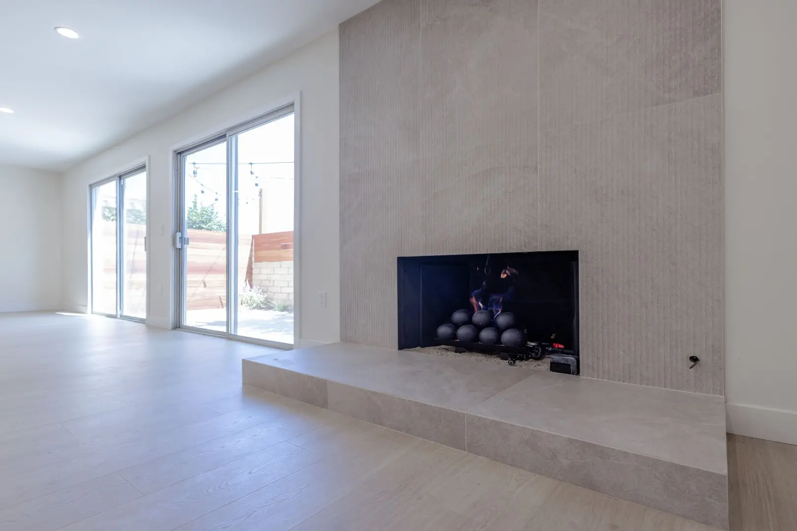 Floor-to-ceiling tile fireplace wall with a raised hearth in a Northridge full-home renovation