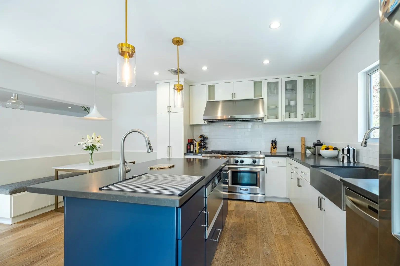 Navy kitchen island with a prep sink facing a stainless range wall in a Santa Monica kitchen remodel