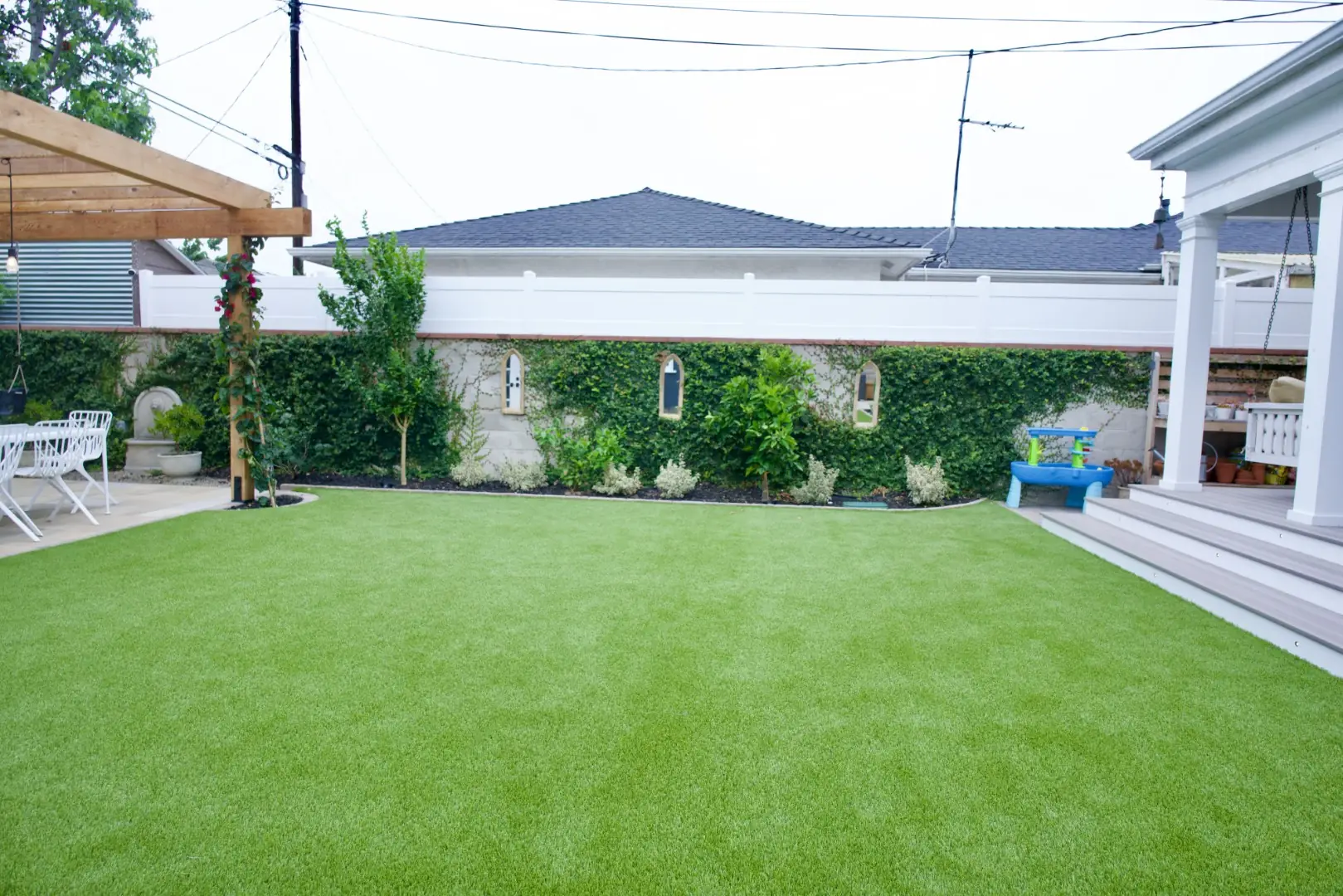 Agnew Project wide turf lawn framed by an ivy-covered wall and trimmed hedges in a Los Angeles backyard