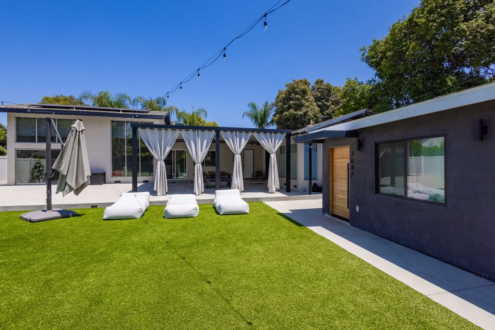 Artificial turf lawn leading to a curtained pergola and modern home in Reseda, Los Angeles