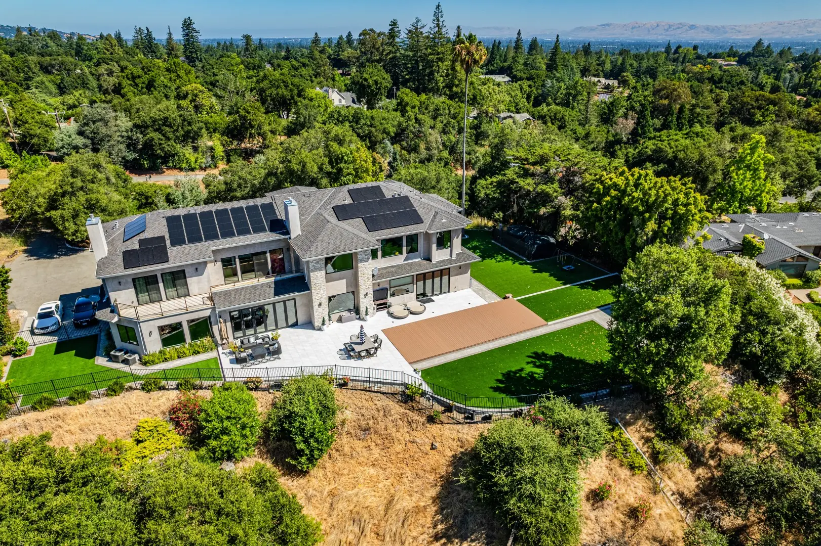 Aerial view of a hillside home with a movable pool deck, lawn, and patio in San Jose, California
