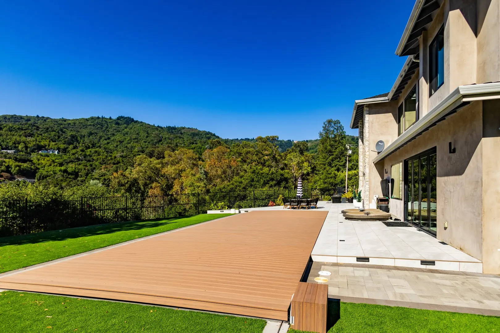 Movable deck fully closed over a pool, forming a flat patio between turf lawns in San Jose, California