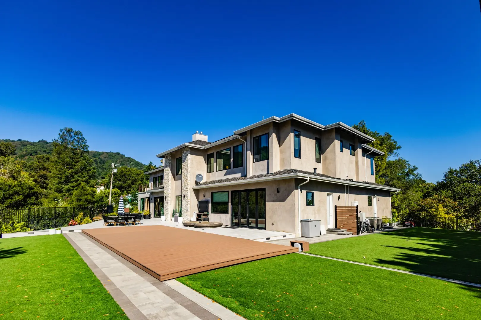 Wide view of a modern home and lawn with a movable pool deck in the closed position in San Jose, California