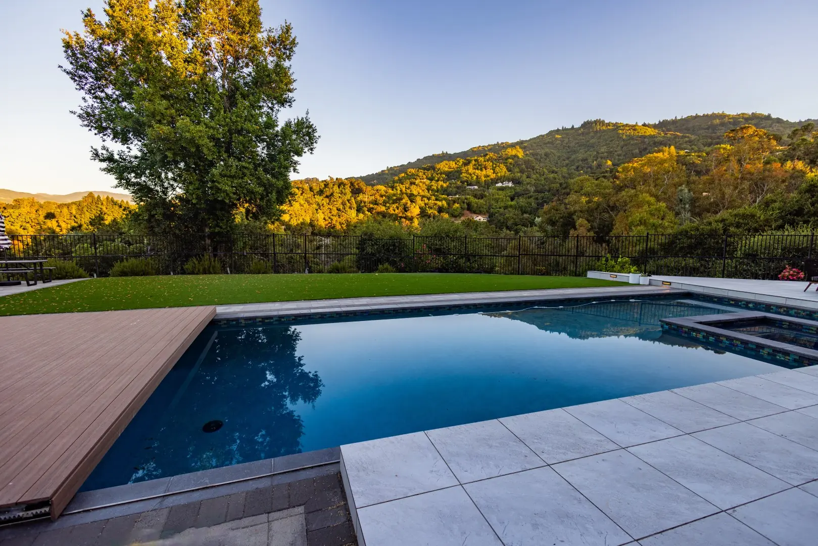 Pool and movable deck at golden hour with wooded hills beyond in San Jose, California