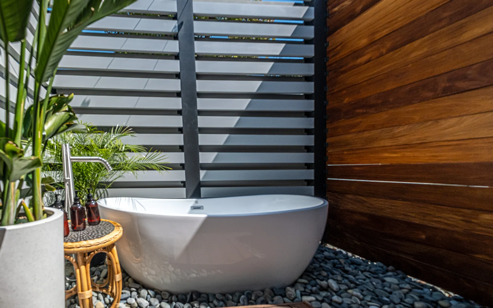 Outdoor living retreat with freestanding soaking tub and wood privacy wall in Los Feliz