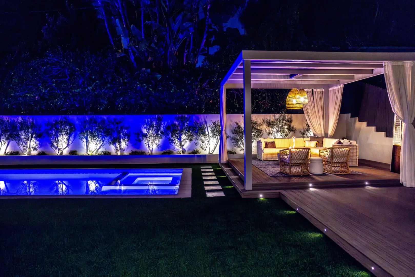 Sheens Project cabana pergola beside the LED-lit pool and spa with stepping stones at night in Los Angeles